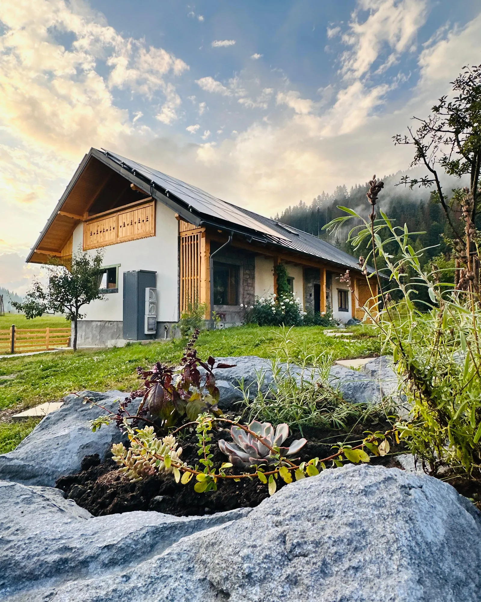 Casa Artcetera Lodge la apus, cu grădina de piatră și ceața peste pădure