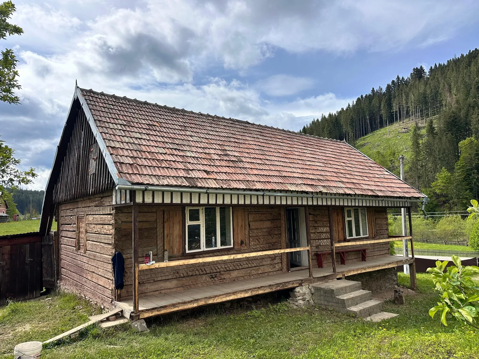 Casa bunicilor din Stulpicani înainte de renovare, cu pereții de lemn și prispa